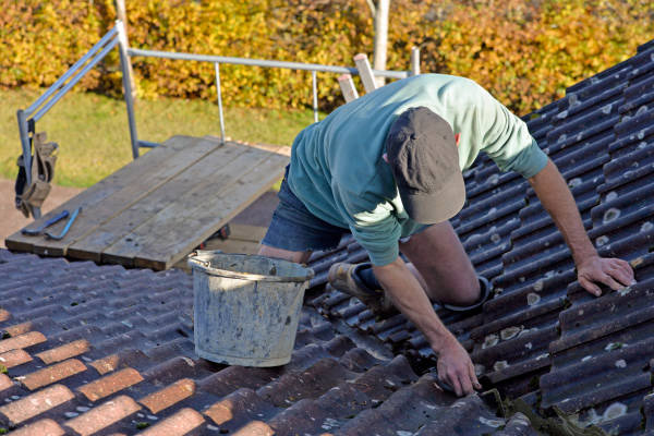 Artisan couvreur en pleine réparation d'une toiture à Robion